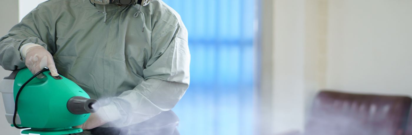 Three commercial cleaners cleaning around a desk