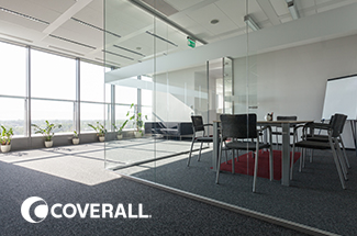 Modern office meeting room with glass walls, large windows, and plants. Logo in corner reads "Coverall."