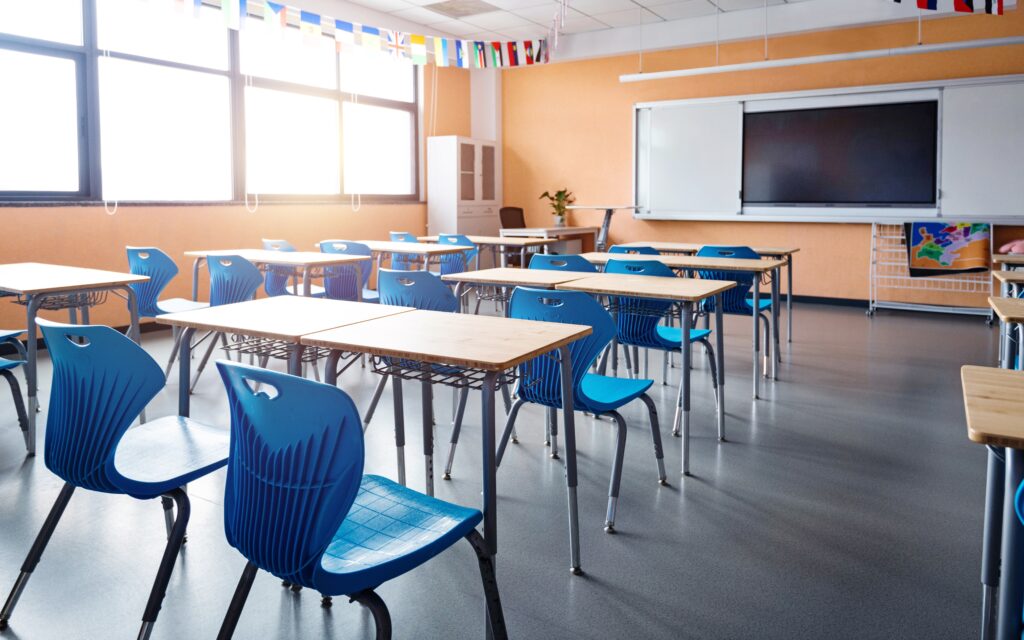 School classroom with desks, chairs and a smartboard.