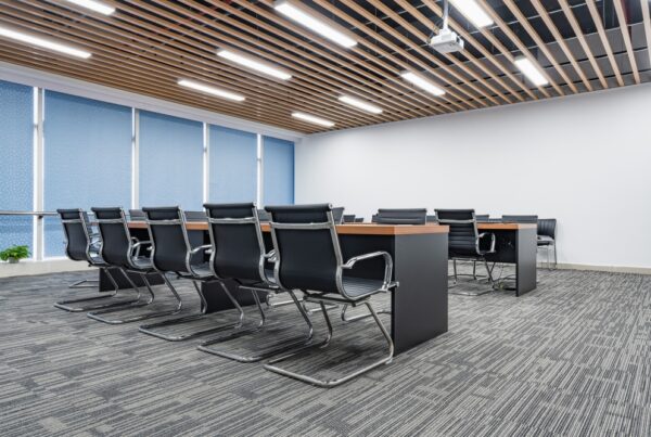 Modern office space with desks, chairs and carpeting.