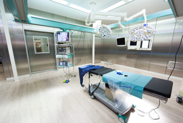 interior of medical exam room with patient table and medical equipment.