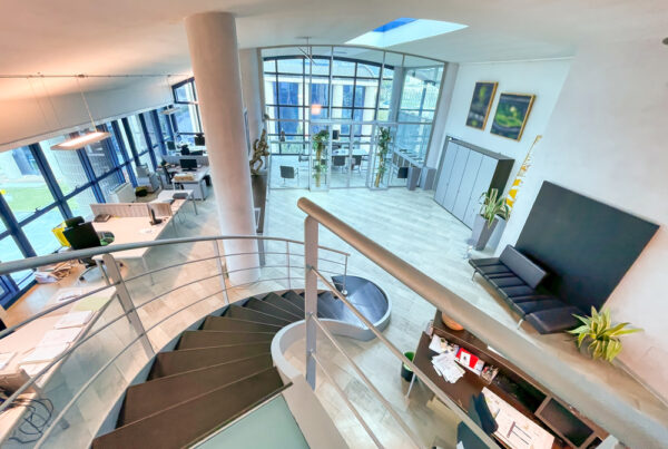 Overhead view of interior office space featuring large windows.