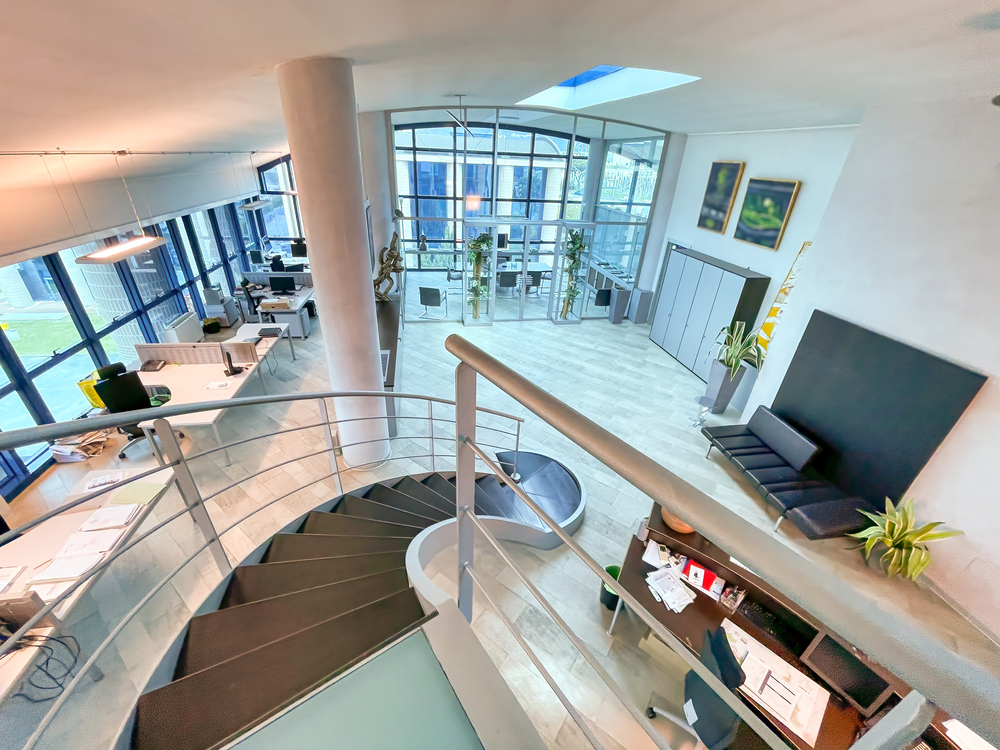 Overhead view of interior office space featuring large windows.