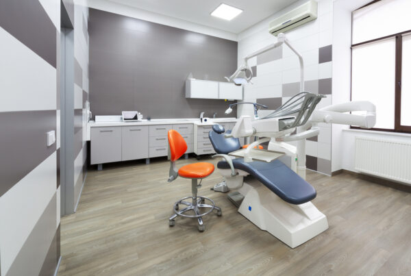 Interior dentist office with an exam chair and dental equipment.