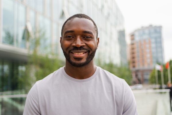 Happy, smiling African American male standing outside.