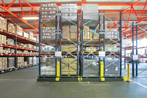 Interior view of an industrial warehouse with exposed beams and shelving with products.