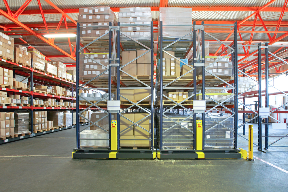 Interior view of an industrial warehouse with exposed beams and shelving with products.